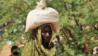 Una mujer acarrea un saco de comida distribuidos en una aldea de Burkina Faso. 