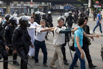 Un grupo de manifestantes partidarios del derrocado presidente Mohammed Morsi son detenidos durante los enfrentamientos con la polic&iacute;a antidisturbios en el Cairo.