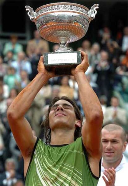 Nadal levanta la Copa de los Mosqueteros tras recibirla de manos del futbolista francés Zidane, al fondo.