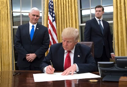 El presidente Donald Trump el 20 de enero de 2017, su primer día en el Despacho Oval, firma la confirmación del nombramiento del secretario de Defensa, James Mattis, ante su vicepresidente Mike Pence (izquierda).