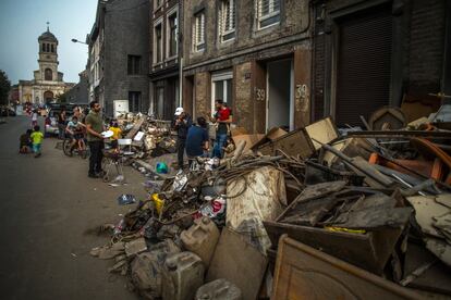 Los servicios de emergencia continúan las operaciones de búsqueda en los lugares más afectados y aseguran muchos edificios que amenazan con derrumbarse. En la imagen, vecinos de Verviers preparan la cena en una acera, frente a una vivienda afectada por las lluvias.