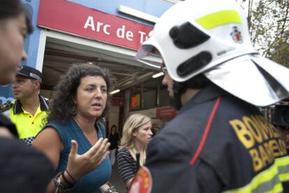 Una pasajera de los trenes afectados habla con un bombero tras el rescate en Barcelona.