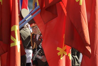 Un soldado norcoreano mira a través de unas banderas del país durante la inauguración. Filas de estas banderas nacionales adornan las principales avenidas de la ciudad.