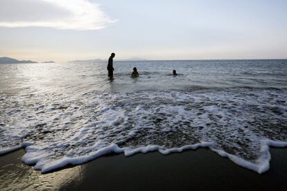 Unas personas disfrutan de las suaves olas de la costa de Banda Aceh, en Indonesia, durante el atardecer del 14 de marzo de 2015. Las aguas indonesias ocupan una superficie de más de 5,8 millones de kilómetros cuadrados, haciendo a este país uno de los principales contribuyentes de productos pesqueros del sureste asiático.