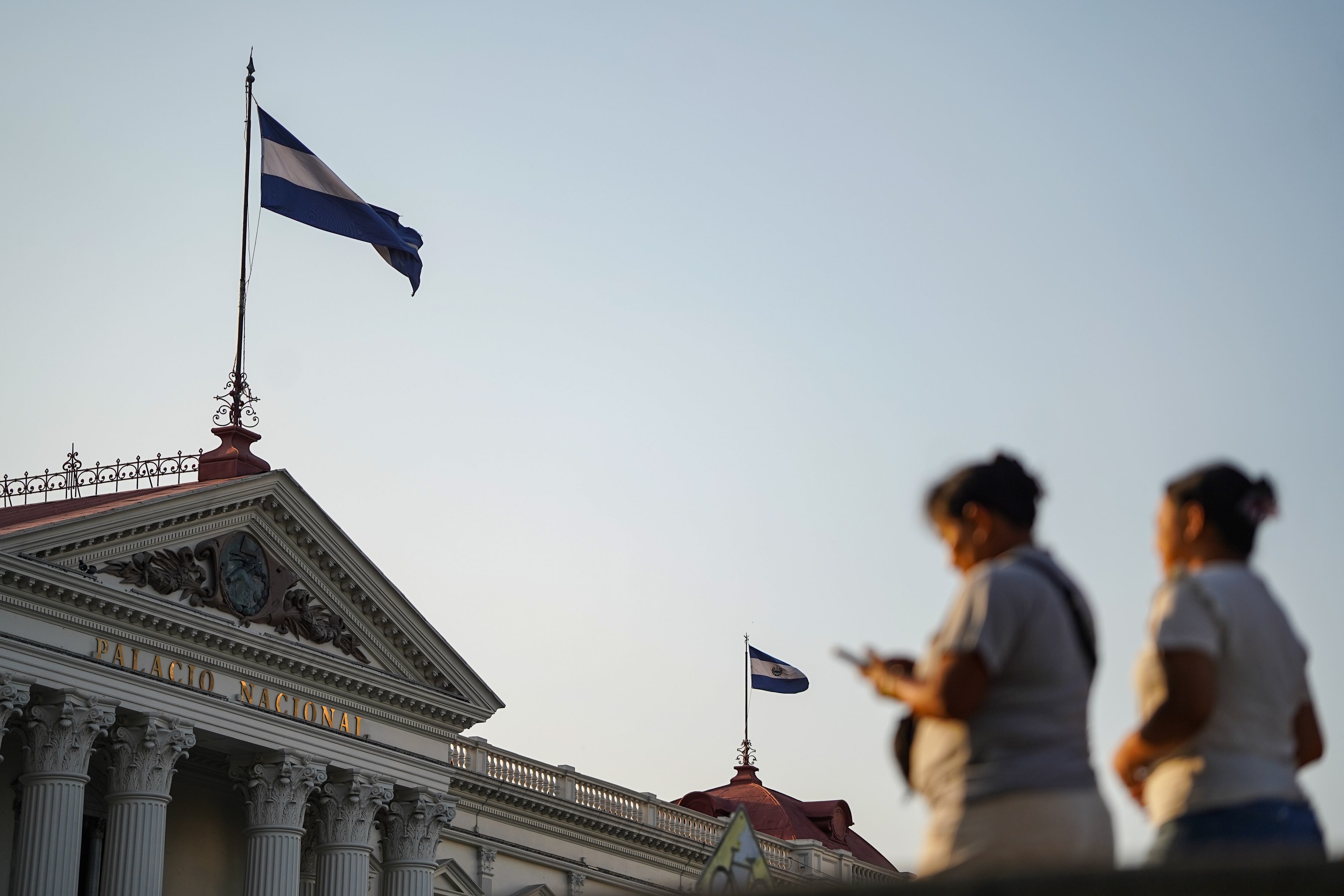 Mujeres caminan frente al Palacio Nacional en San Salvador, el 16 de abril.