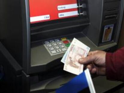 Un hombre retira dinero de un cajero automático. EFE/Archivo