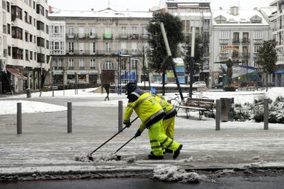 Dos operarios limpian una calle de Vitoria. 