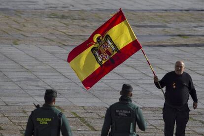 Agentes de la Guardia Civil se disponen a quitar una bandera preconstitucional a uno de los asistentes al Valle de los Caídos.