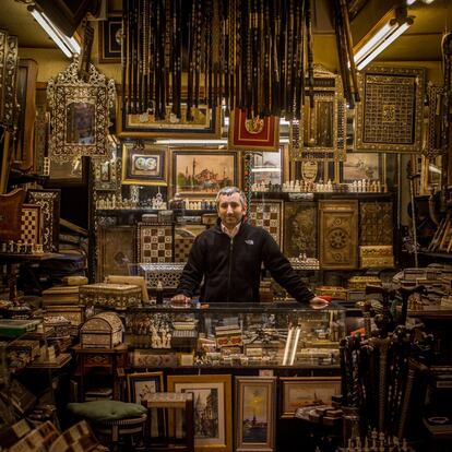 Serkan Almaz, sonríe, en el centro de su tienda de tableros de chaquetes y ajedrez hechos a mano, en el Gran Bazar de Estambul (Turquía).