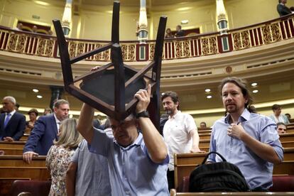 Movimiento de sillas en el hemiciclo del Congreso momentos antes del inicio de la segunda sesión de debate de investidura celebrado este martes en la cámara baja. En la imagen, el líder de Podemos, Pablo Iglesias (derecha).