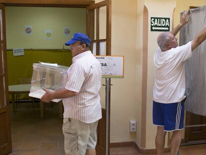Dos operarios preparan un colegio electoral en Sevilla.