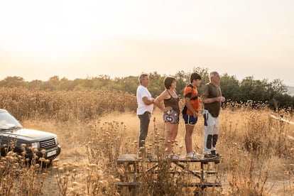 Una familia contempla desde una colina el incendio que amenaza el Parque Natural de Monfragüe (Cáceres), este sábado. Los distintos dispositivos de extinción se enfrentan a 33 incendios: 14 activos, 15 controlados y cuatro estabilizados, según datos de los servicios de emergencias de las distintas comunidades autónomas y de la Dirección General de Protección Civil.