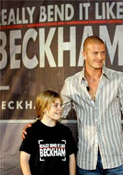 David Beckham, con una niña inglesa, en la presentación del DVD sobre clases de fútbol en Madrid.