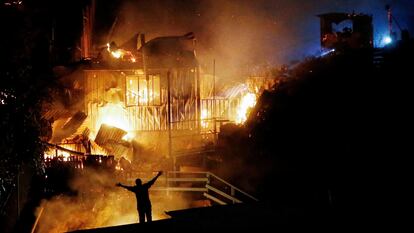 Una persona observa casas arder en medio de un nuevo incendio forestal en Valparaíso, Chile, el 13 de marzo.