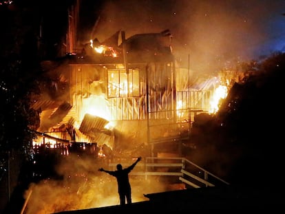 Una persona observa casas arder en medio de un nuevo incendio forestal en Valparaíso, Chile, el 13 de marzo.