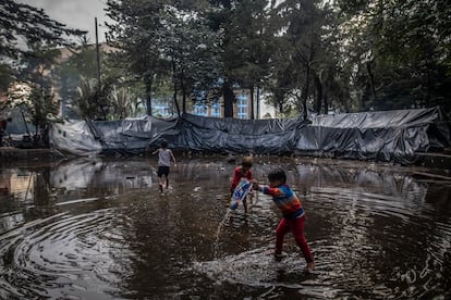 Niños indígenas juegan en la fuente de agua sucia, en el Parque Nacional de Bogotá, Colombia, en abril de 2022.