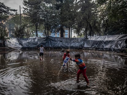 Niños indígenas juegan en la fuente de agua sucia, en el Parque Nacional de Bogotá, Colombia, en abril de 2022.