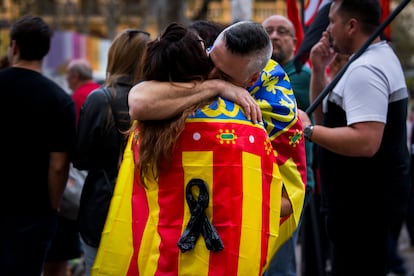 Dos manifestantes se abrazan con la bandera valenciana frente al Ayuntamiento. 