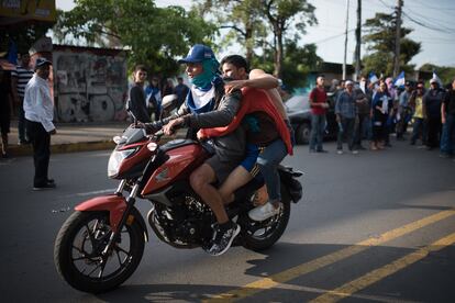 Jóvenes trasladan a uno de los heridos durante la protesta.