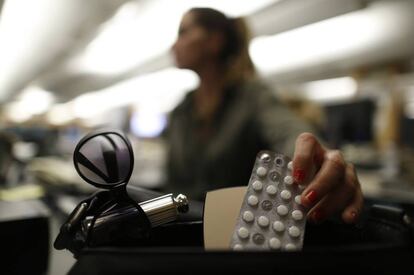 A woman pulls lorazepam pills from her purse.