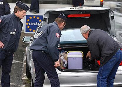 Dos policías franceses revisan un coche en la frontera con España tras los atentados del 11 de marzo.