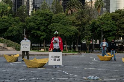 Una mujer sostiene un cartel con la frase "Nos faltan +100 mil", este martes en el Ángel de la Independencia.