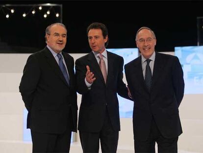 Pedro Solbes (izquierda) y Manuel Pizarro (derecha) posan junto al moderador del debate, Matías Prats.