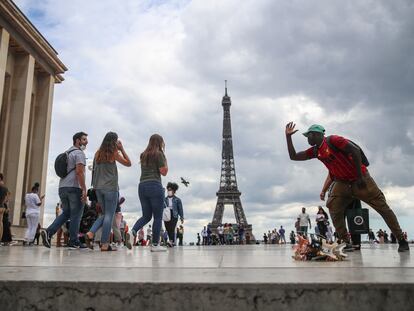 Un grupo de personas, junto a la Torre Eiffel, en París, este viernes.
