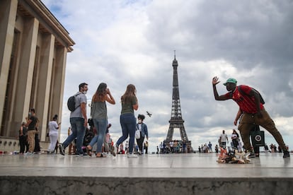 Un grupo de personas, junto a la Torre Eiffel, en París, este viernes.