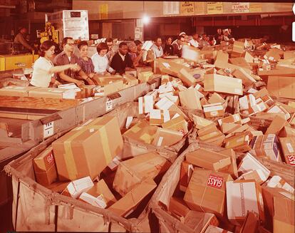 Trabajadores de una empresa postal clasifican paquetes en Navidad.