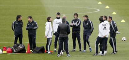 Mourinho, de espaldas en el centro, charla con algunos jugadores durante el entrenamiento de ayer en Valdebebas.