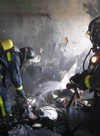 Dos bomberos, en el piso donde se han originado las llamas, que ha quedado destrozado.