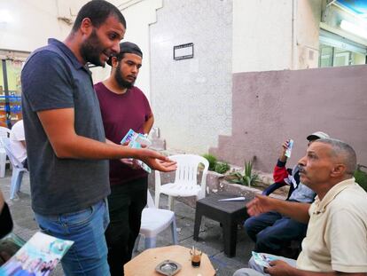 Amen Alá Jawhary intentando convencer a un anciano de que le vote en un café de Manuba.