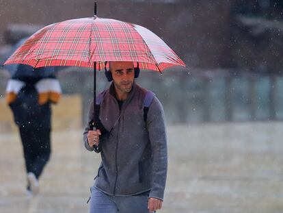 Un joven se protege de la lluvia en una calle de Málaga, el 14 de marzo.