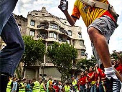 Unos jóvenes bailan ante La Pedrera durante la <i>Carnavalona</i> que se celebró ayer en Barcelona.