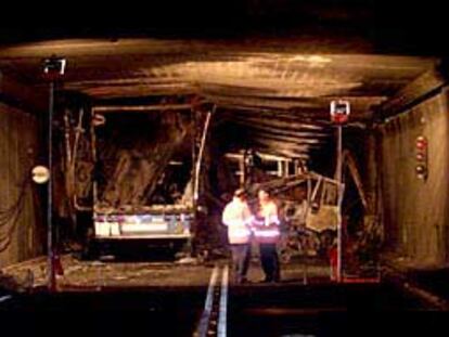 Dos miembros de los equipos de rescate cambian impresiones en el interior del túnel de San Gotardo.