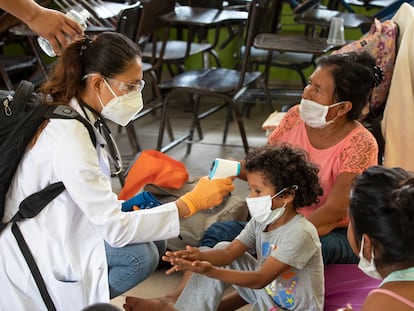 Una doctora toma la temperatura de una familia en Cabo, San Lucas, México.