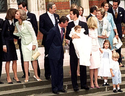 La Reina besa en Londres a una de las invitadas al bautizo del hijo del príncipe Pablo de Grecia, que aparece con el niño en el centro.
