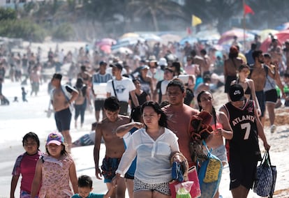 Vacacionistas caminan por la playa Gaviota Azúl en Cancún (Quintana Roo), este viernes.