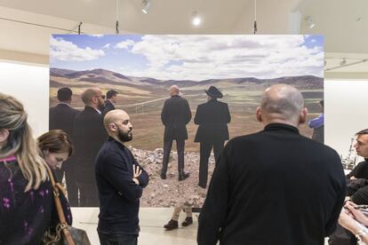 Koolhaas observauno de los paneles de la exposición, en el que sale explorando un terreno de campo. |