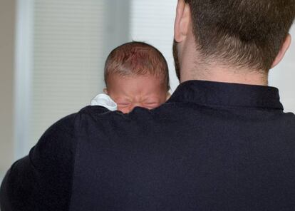 Un padre con su bebé en brazos.