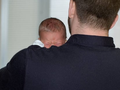 Un padre con su bebé en brazos.