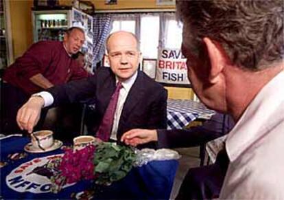 El líder consevador, William Hague (en el centro), visita a un pescador durante su campaña en la ciudad de Hastings.