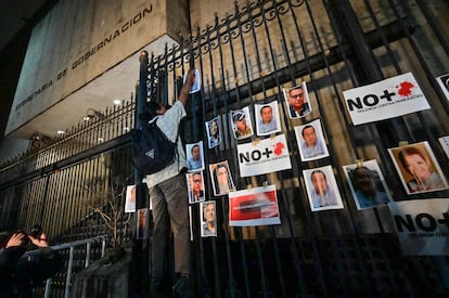 Los crímenes contra la prensa se convirtieron desde inicios de año en una gran mancha en el expediente del Gobierno de López Obrador. El Parlamento Europeo llegó a condenar la situación de extrema violencia en la que trabajan los reporteros en el país. El presidente, que ya contaba en ese momento con ocho profesionales acribillados, acusó a sus adversarios políticos de estar aliados con los conservadores europeos para dañar su imagen. En la imagen, un periodista cuelga imágenes de comunicadores asesinados en una de las rejas que rodean la sede de la secretaría de Gobernación, en Ciudad de México, el 14 de febrero de 2022.