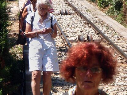 Los pasajeros se dirigen a la estación por las vías tras salir del funicular.