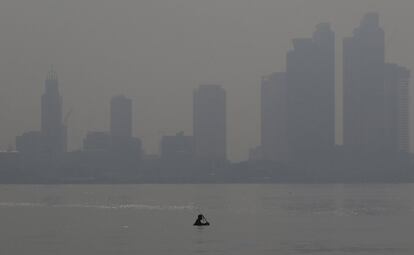 Un pescador filipino nada en las aguas turbias de la Bahía de Manila en Filipinas mientras la niebla envuelve a los edificios. Todavía muchos se bañan en estas aguas a pesar de que el gobierno ha alertado de que es perjudicial para la salud. 