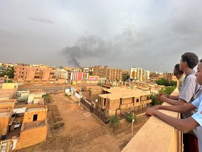 Unos adolescentes observan el humo de los combates entre el ejército y paramilitares en la ciudad sudanesa de Omdurman, el 4 de julio.