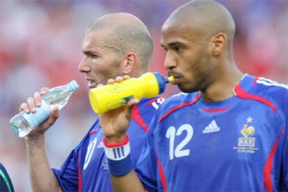 Zidane y Henry se refrescan durante el encuentro contra Suiza.