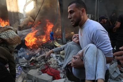 Un hombre evacúa a una niña herida tras el impacto de un bombardeo israelí en Rafah, al sur de la franja de Gaza, este viernes. 