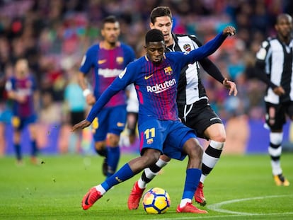 Demb&eacute;l&eacute; golpea el bal&oacute;n ante la presi&oacute;n de Lukic.